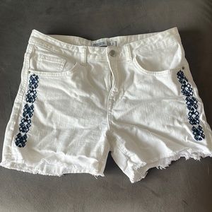White jean shorts with navy detail.